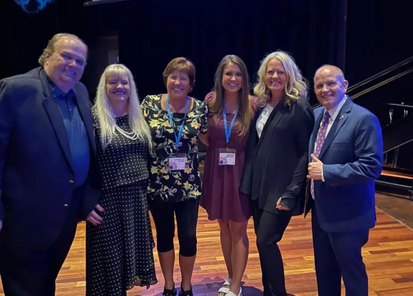 A group of people are posing for a picture on a stage.