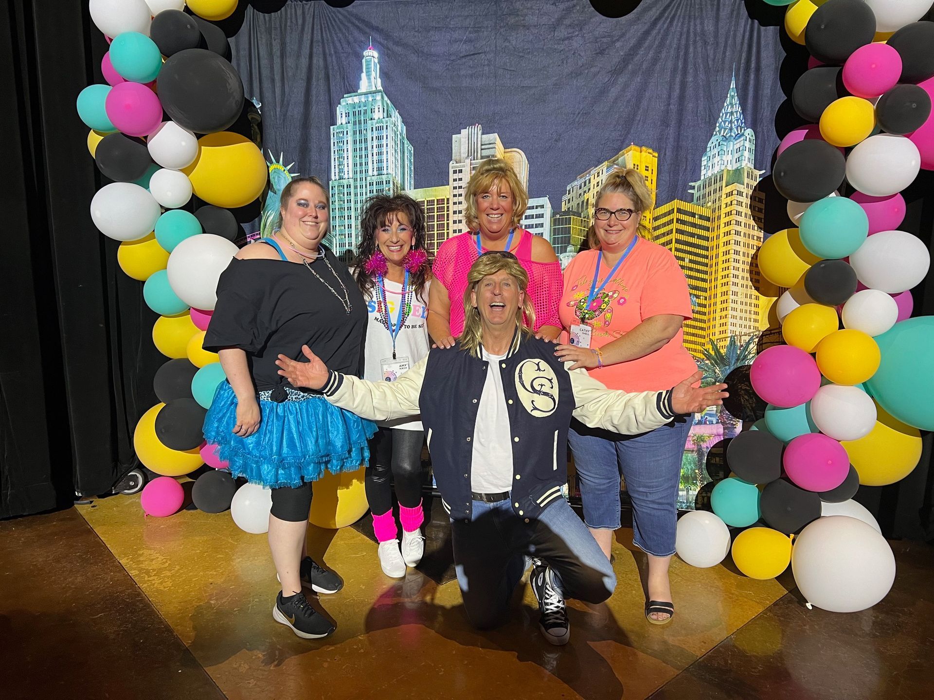 A group of people are posing for a picture in front of balloons.