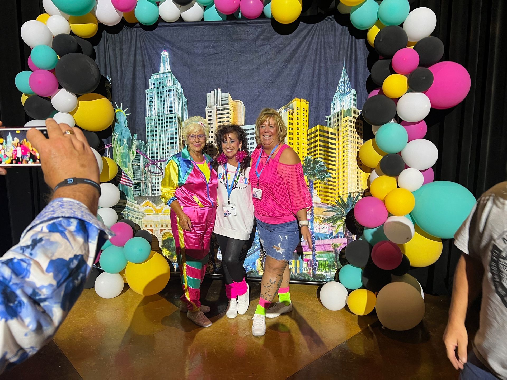 A group of people are posing for a picture in front of balloons.