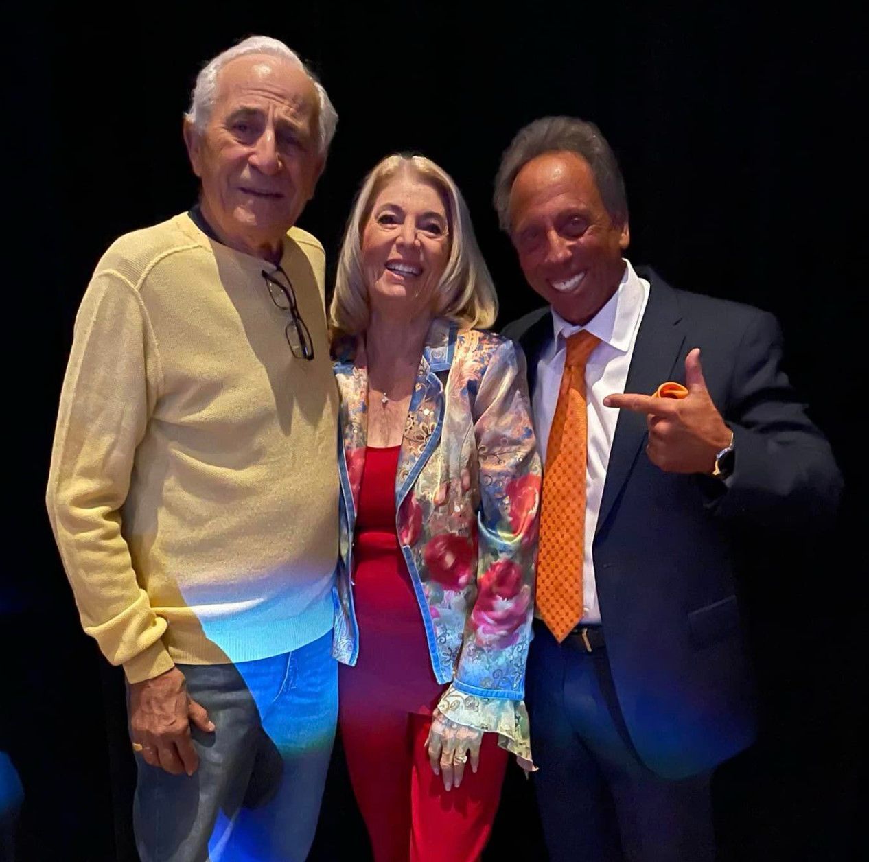 Three people posing for a picture with one pointing at the camera