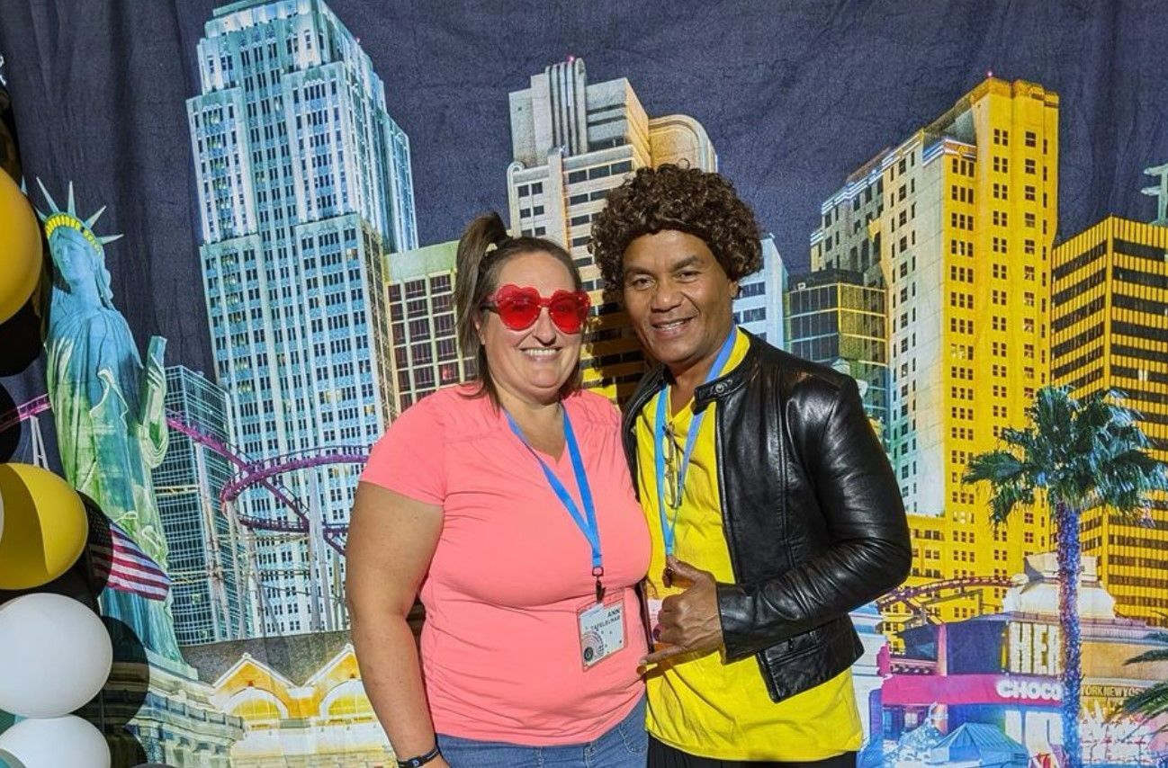 A man and a woman are posing for a picture in front of a city backdrop.