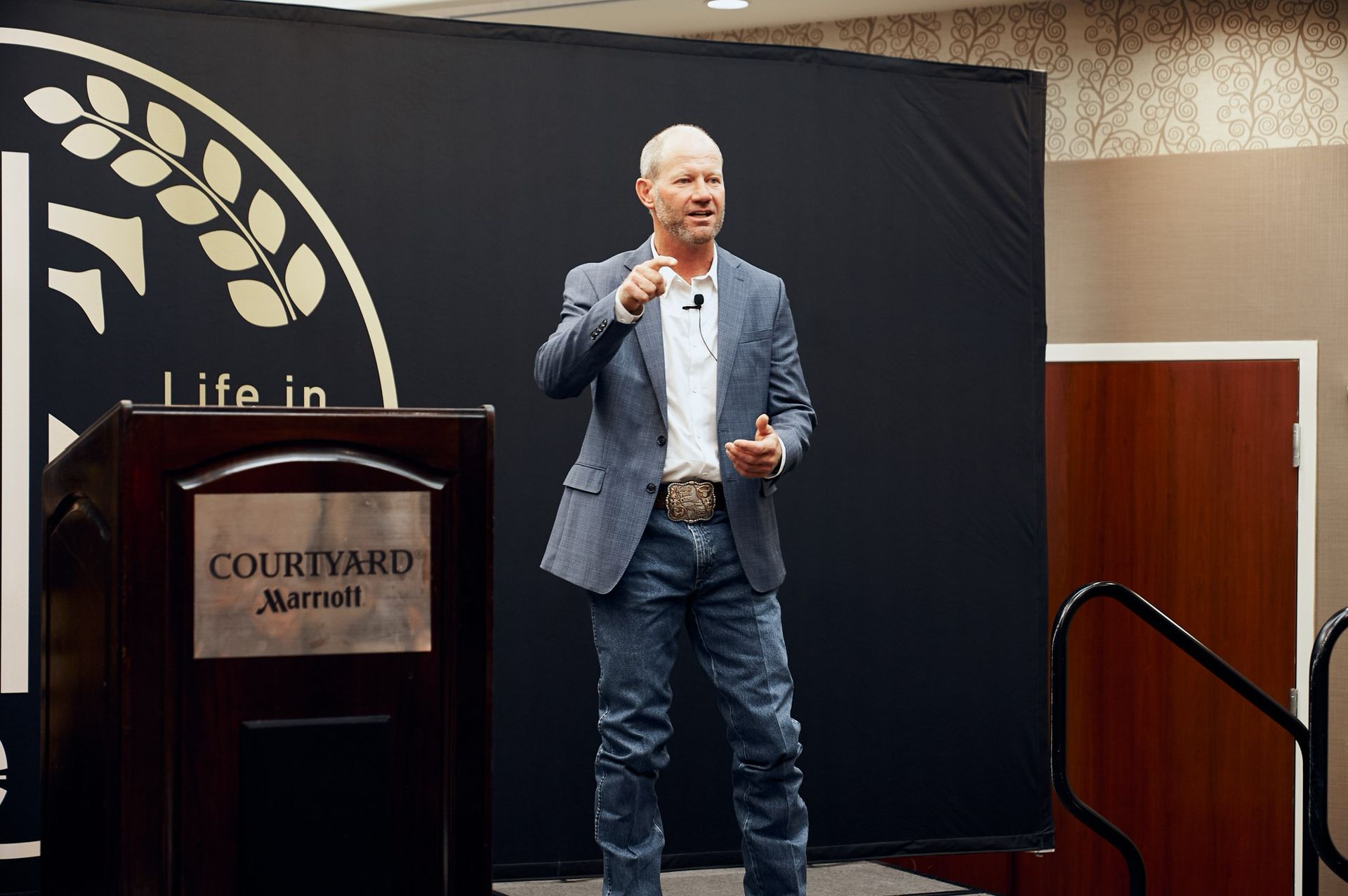 A man in a suit is standing at a podium giving a presentation.