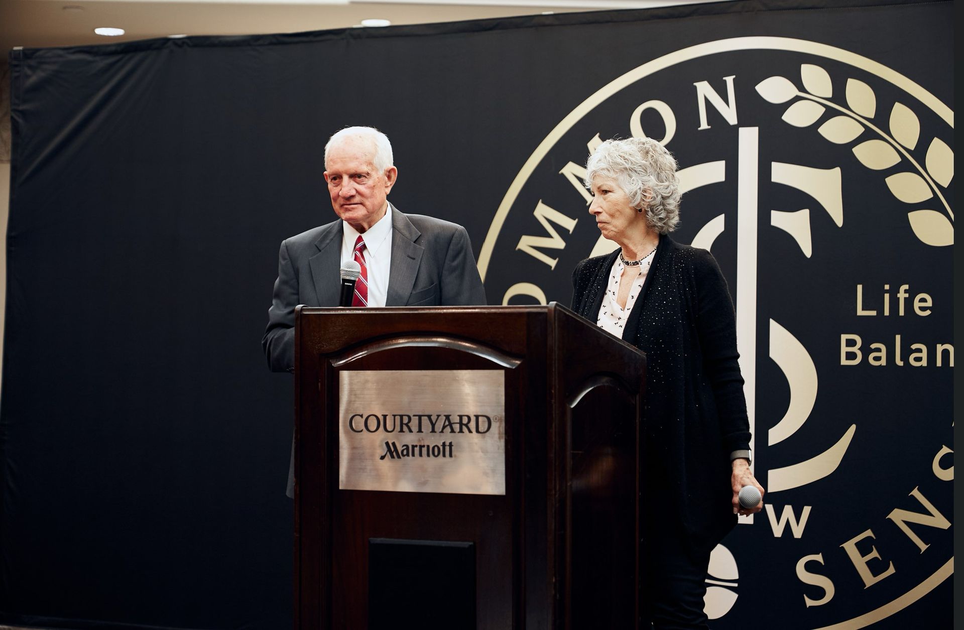 A man and woman are standing at a podium that says courtyard marriott