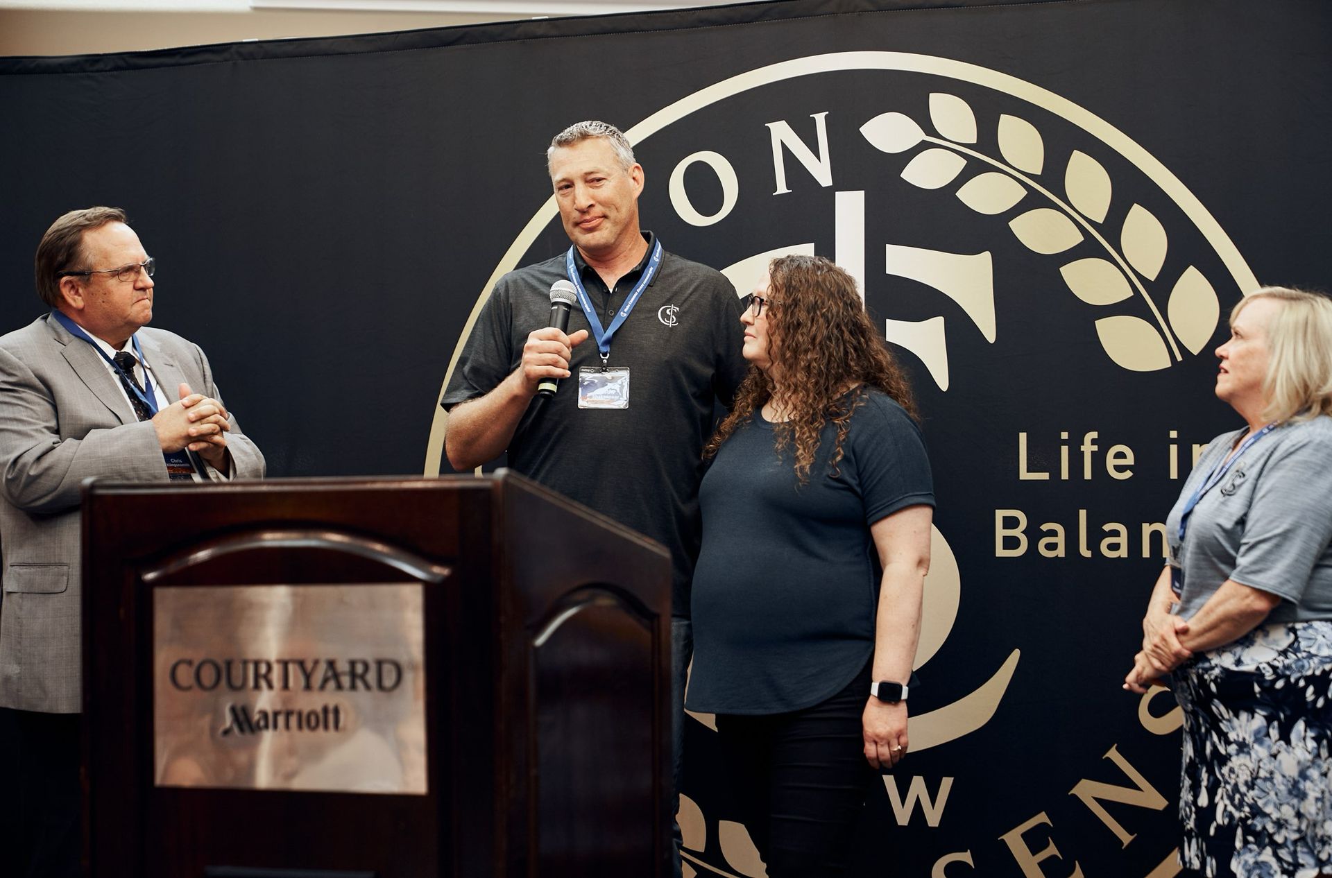 A man is standing at a podium talking to a group of people.