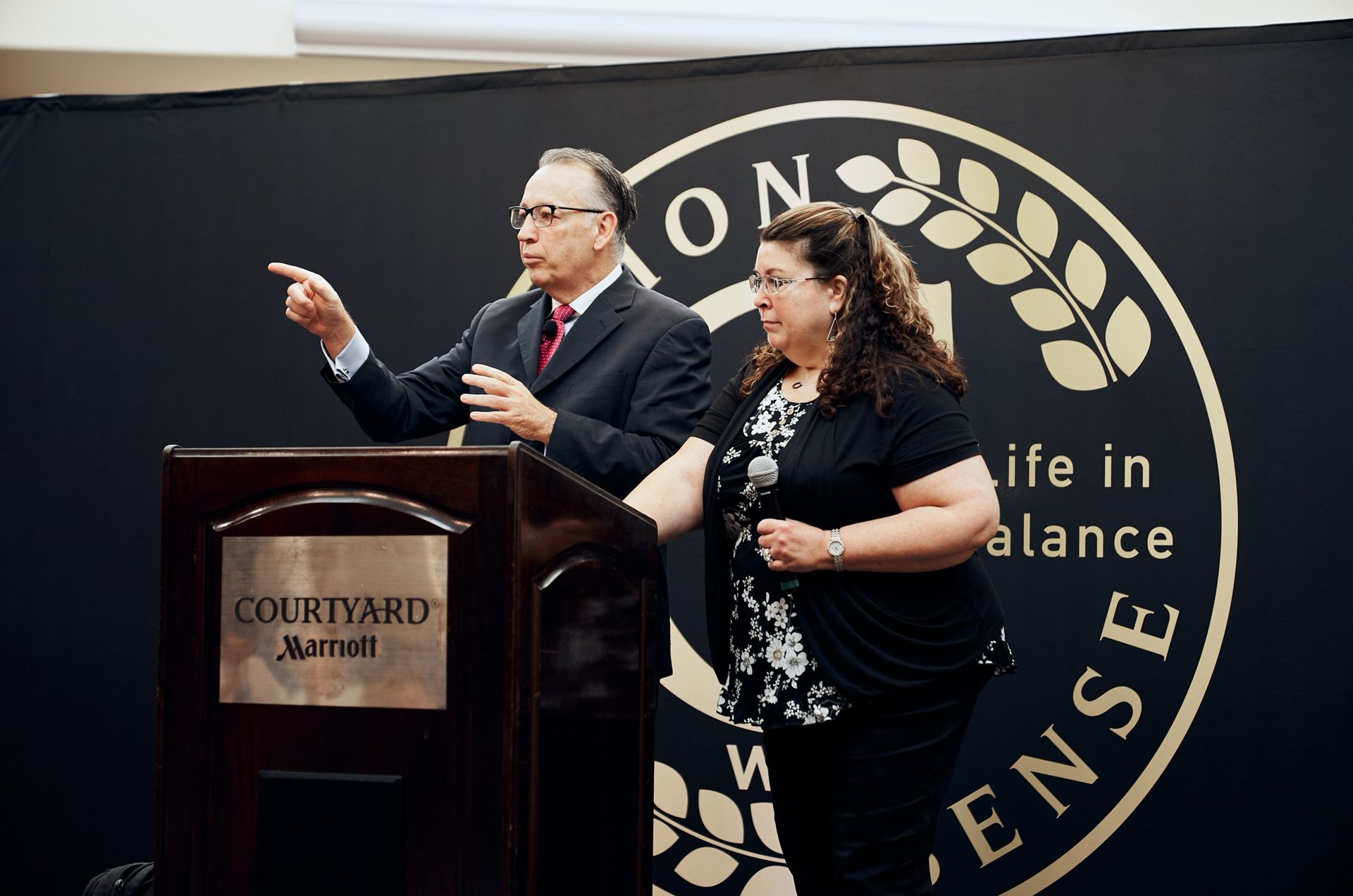 A man and a woman are standing at a podium that says courtyard marriott