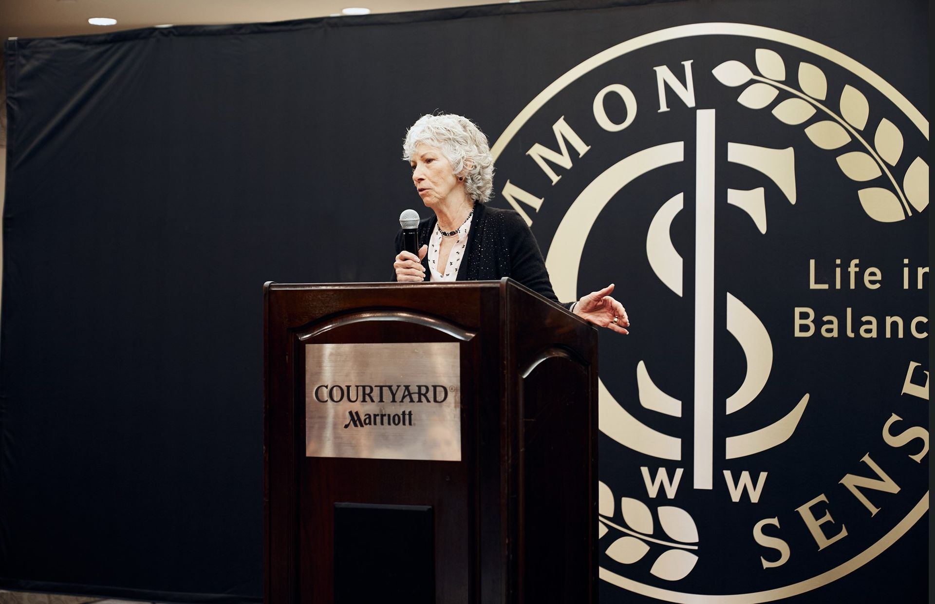A woman stands behind a podium that says courtyard marriott