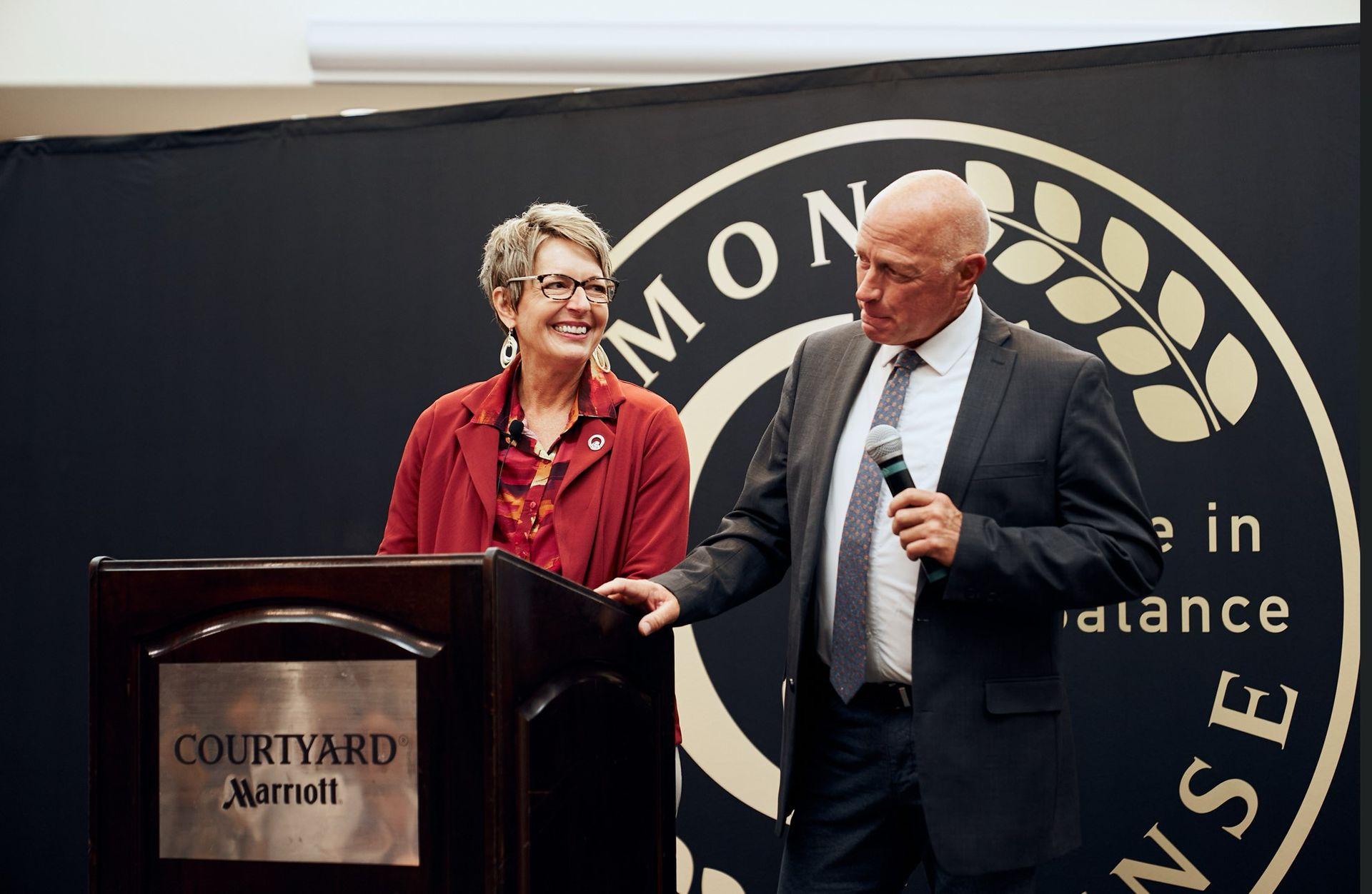 A man and a woman are standing behind a podium that says courtyard marriott