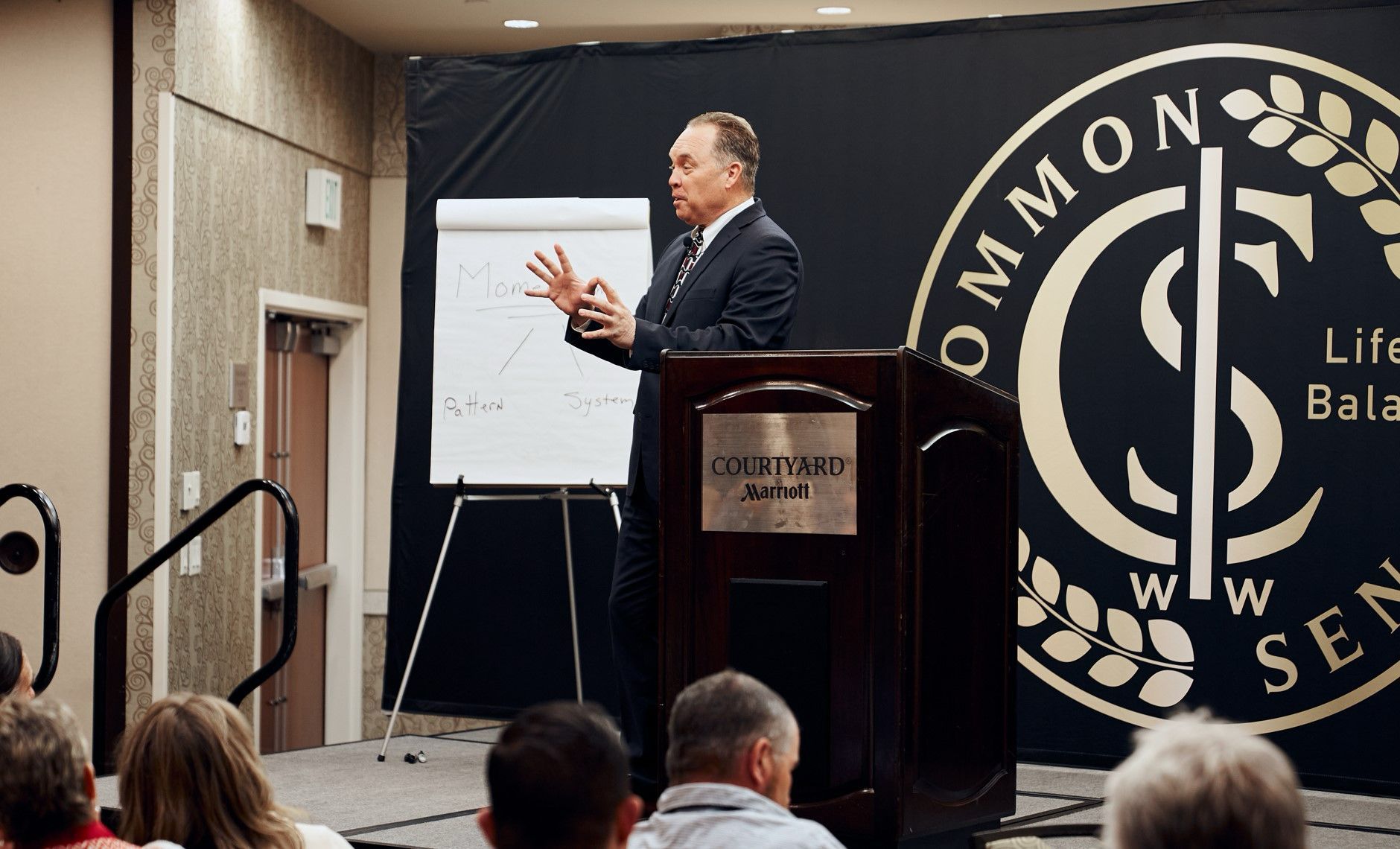 A man is standing at a podium giving a presentation to a group of people.