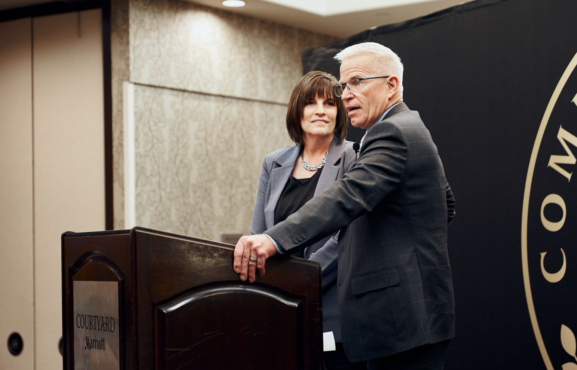 A man and a woman are standing behind a podium.