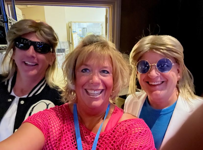 Three people are posing for a picture and one of them is wearing sunglasses