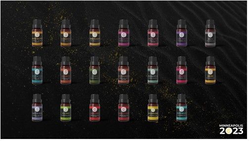 A bunch of bottles of paint are lined up on a black surface.