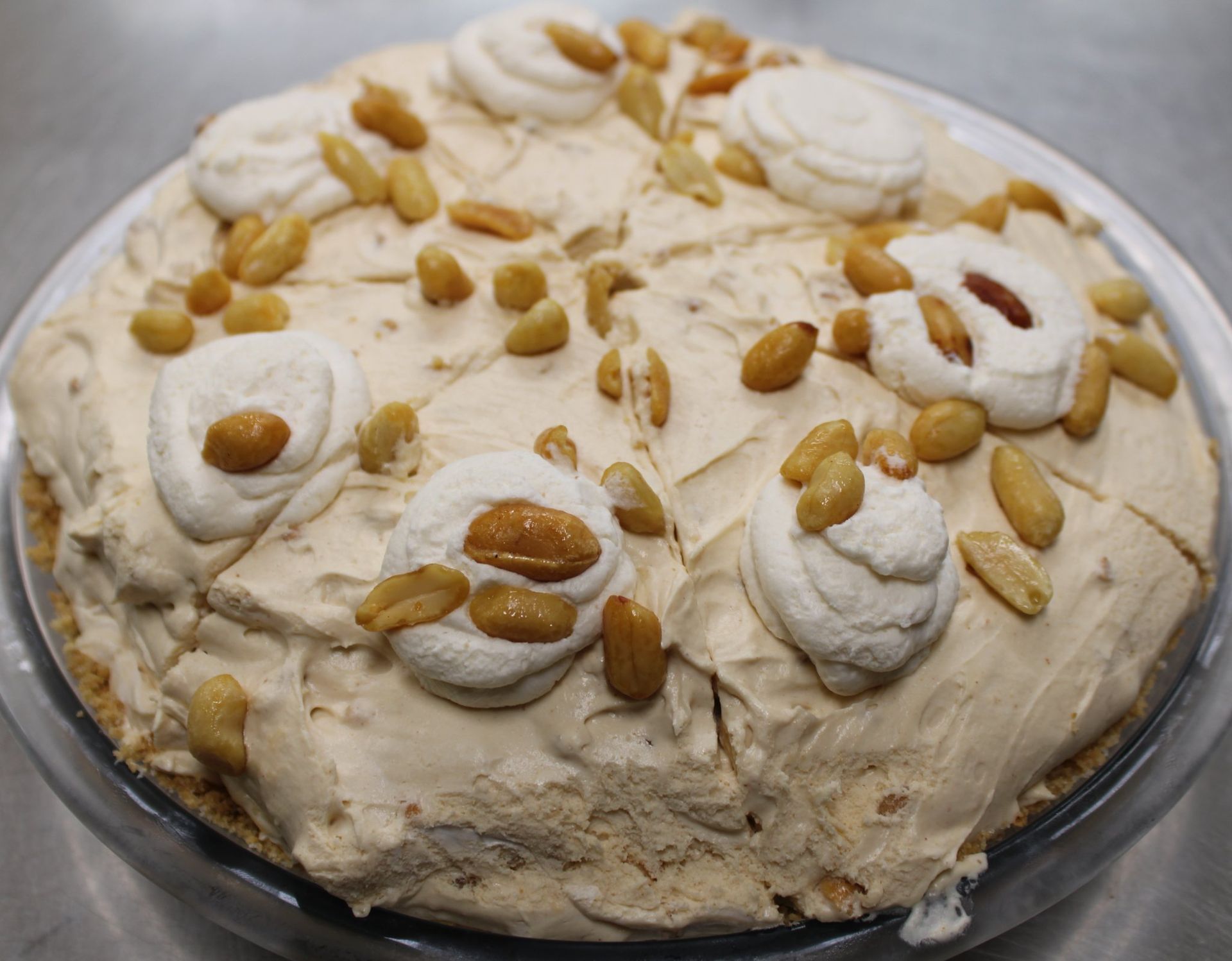 A peanut butter pie with whipped cream and peanuts on top