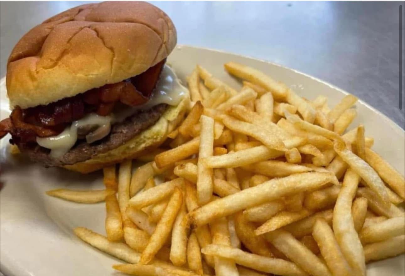 A hamburger and french fries on a white plate.