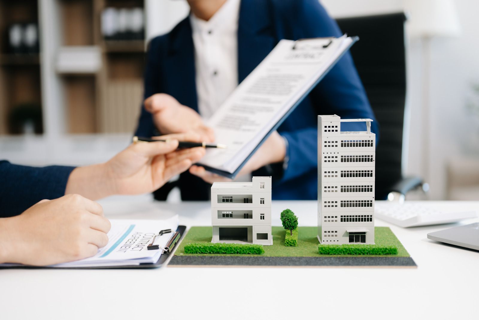 Laptop, calculator, documents, and glasses on a desk, possibly financial or tax-related work.