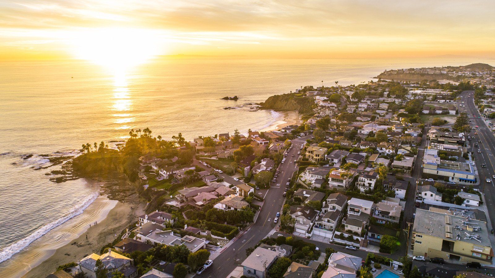 A white truck is parked in a parking lot next to a building.