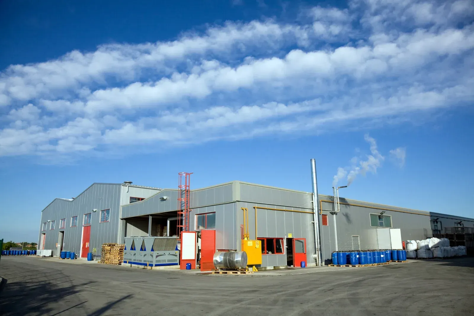 Blue house with white trim, green lawn, and blue sky.