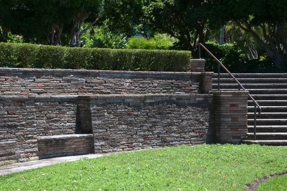 a stone wall with stairs leading up to it in a park
