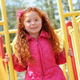 Little girl with pink jacket smilling- Childcare in Bayville, NJ