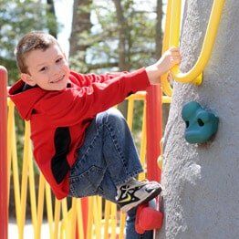 Little boy with red jacket climbing- Childcare in Bayville, NJ