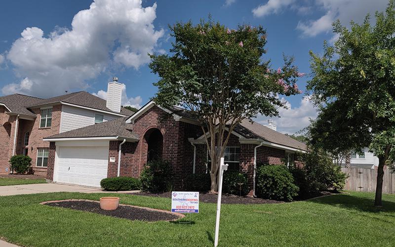A house with a for sale sign in front of it