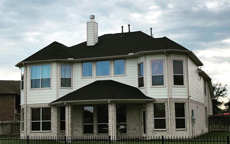 A large white house with a black roof and many windows