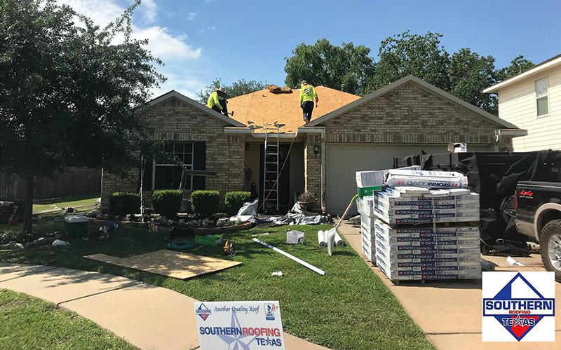 A group of people are working on the roof of a house.