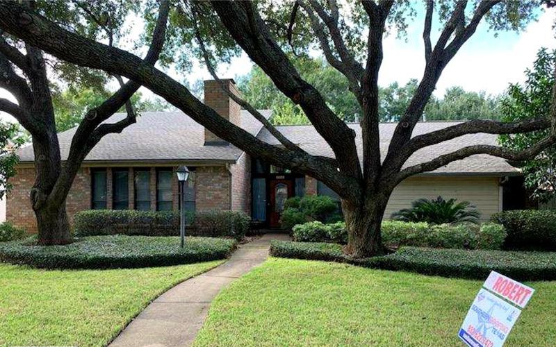 A house with a for sale sign in front of it