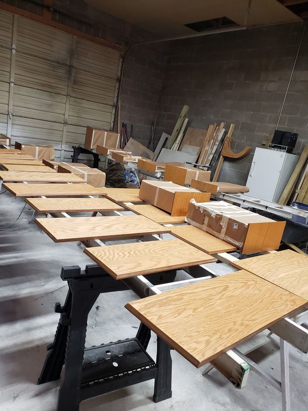 A warehouse filled with wooden tables and boxes.