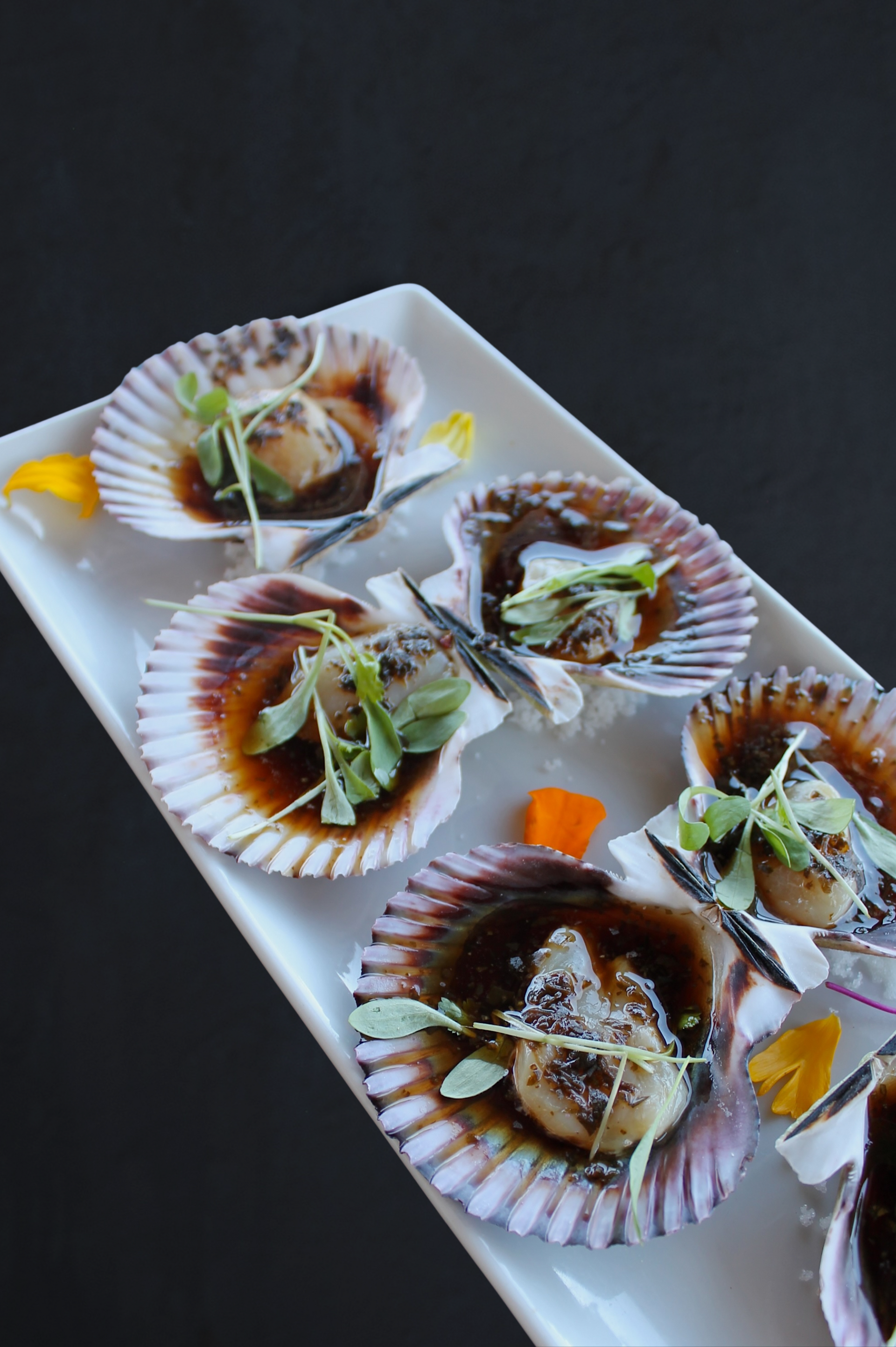 queen scallops, prepared with housemade ponzu basil sauce and topped with micro cilantro. 
