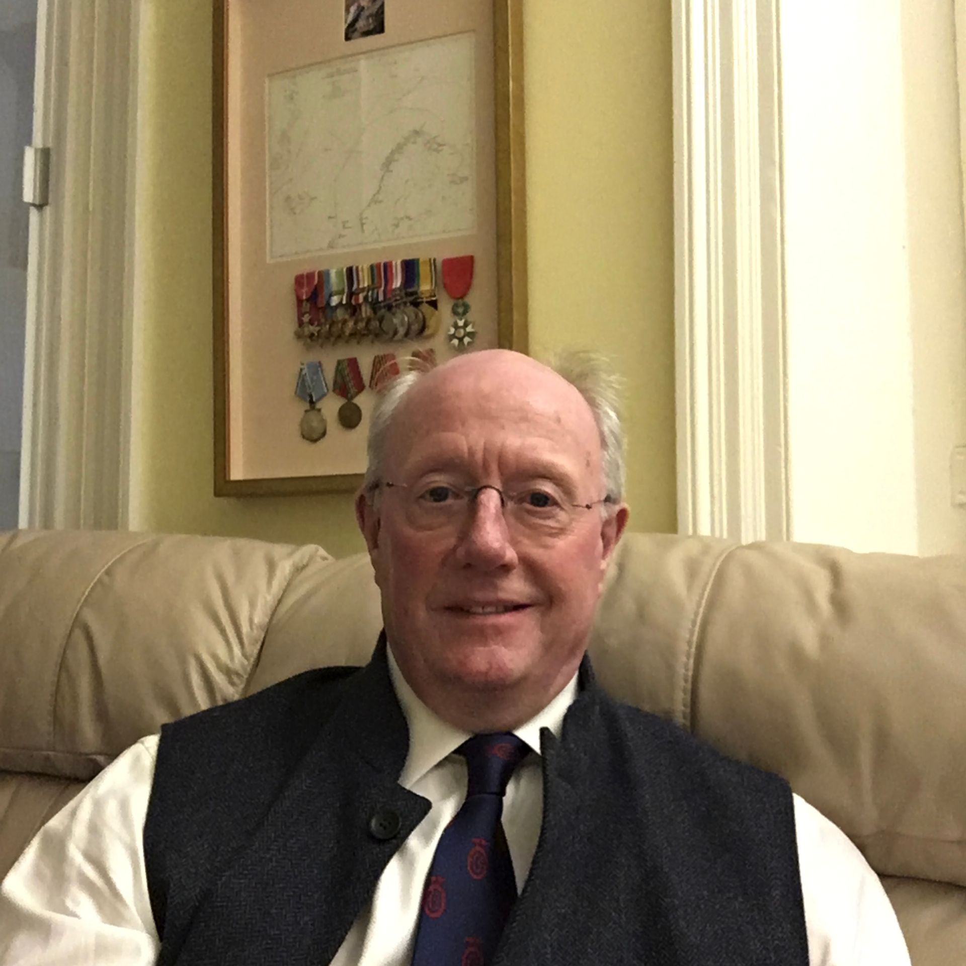 a man wearing a shirt and tie is sitting on a couch