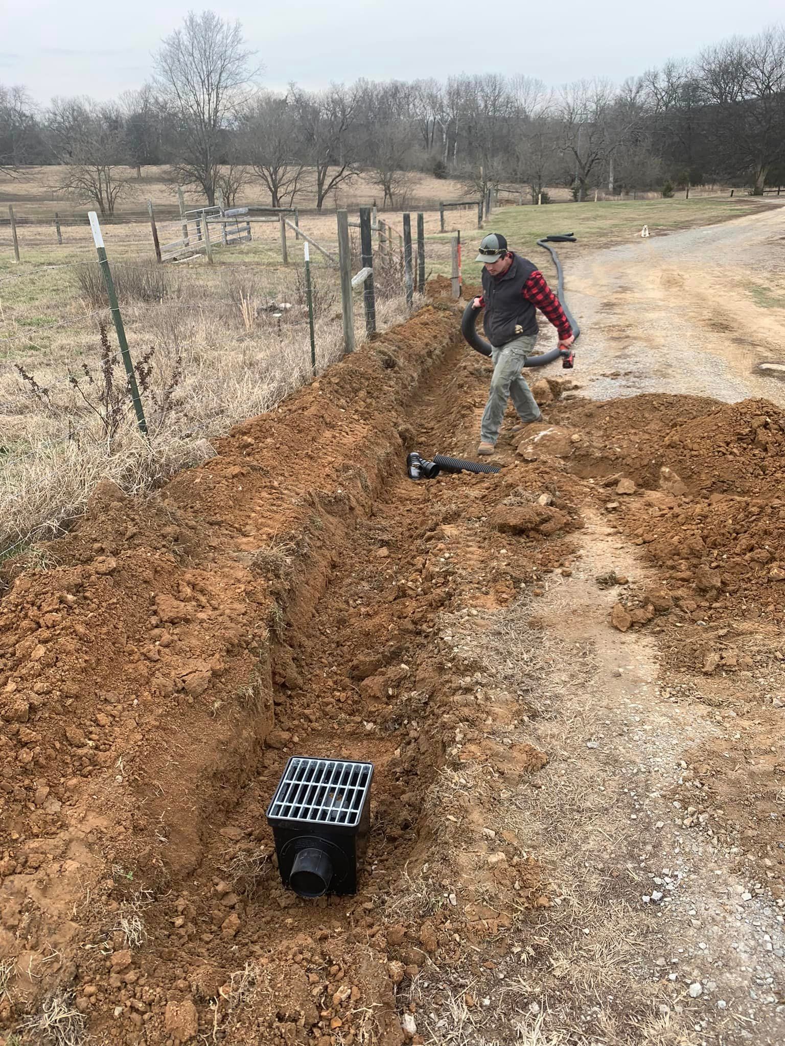 A man is digging a hole in the dirt with a shovel.