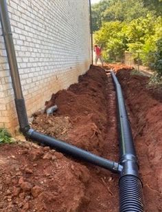 A man is pumping a hose into a septic tank.