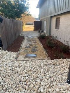 A lush green lawn surrounded by rocks and bushes.