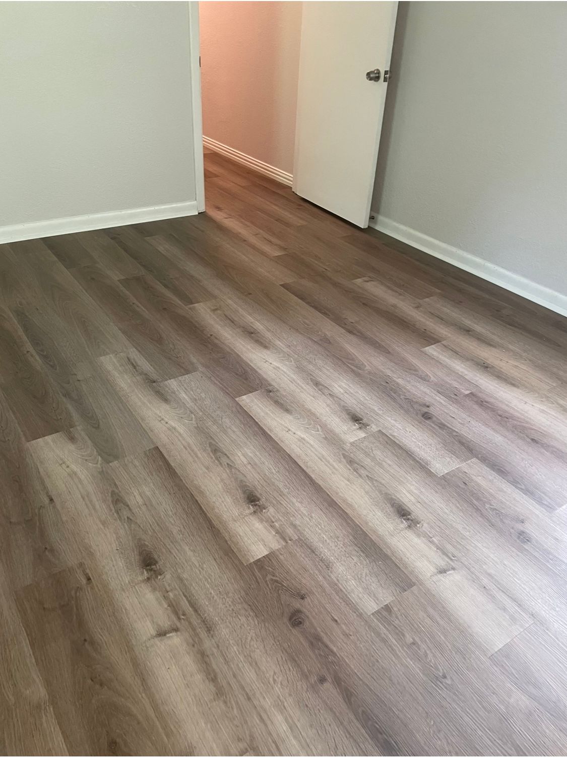 A room with a wooden floor and a door.