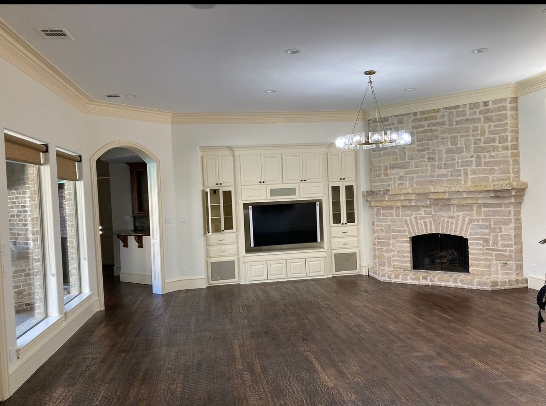 An empty living room with a fireplace and a flat screen tv.