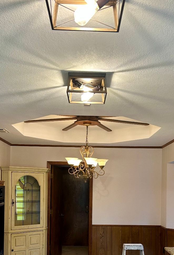 A ceiling fan is hanging from the ceiling of a dining room.