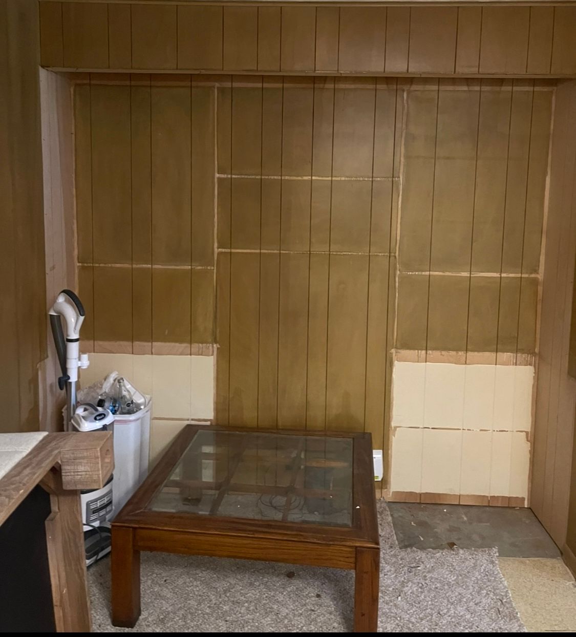 A room with wood paneling and a glass coffee table