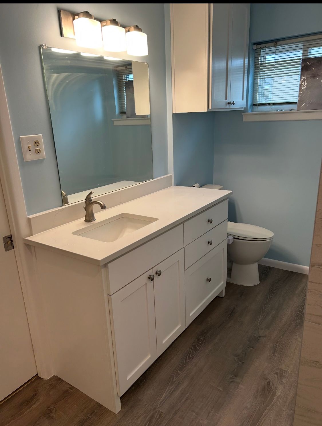 A bathroom with a sink , toilet and mirror.