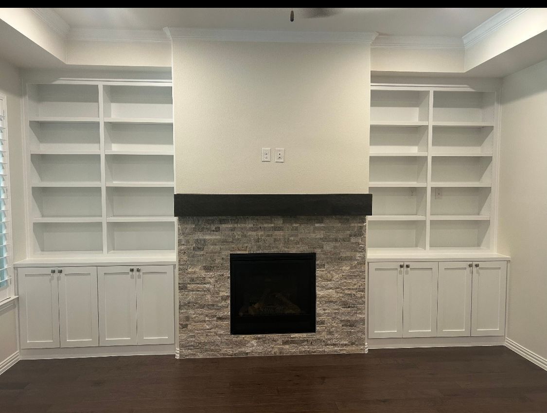 A living room with a fireplace and built in shelves