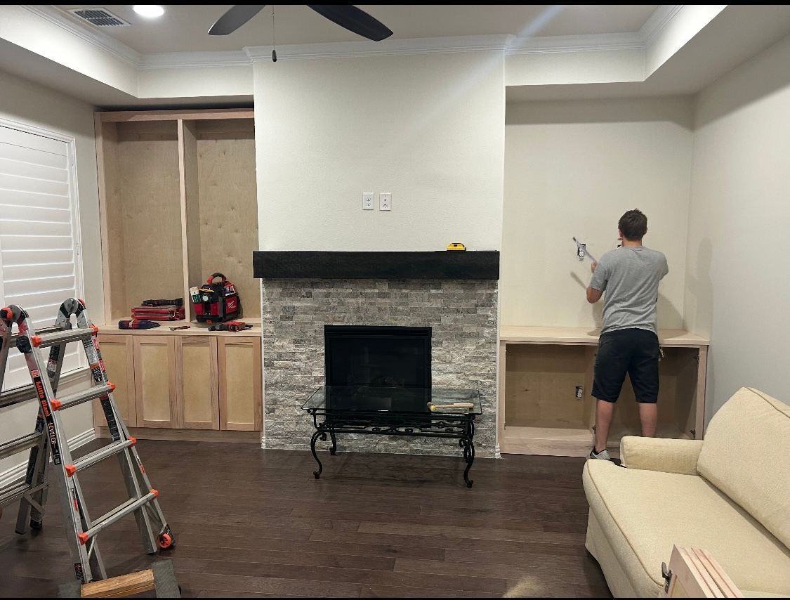 A man is working on a fireplace in a living room.