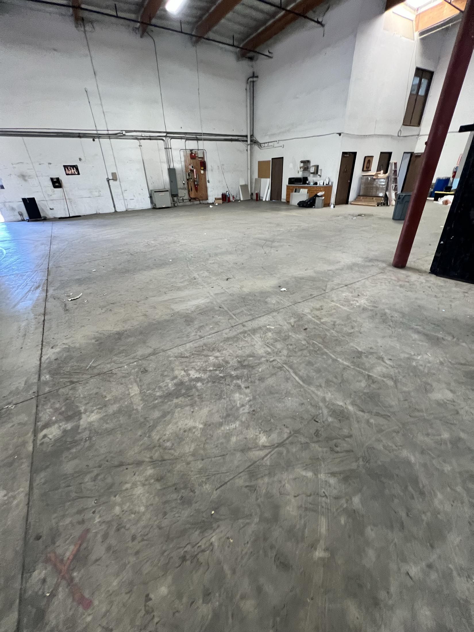 A large empty warehouse with a concrete floor and white walls.