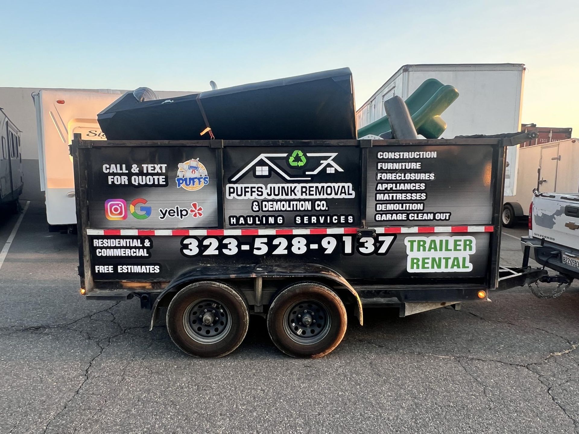 A trailer with a lot of furniture on it is parked in a parking lot.