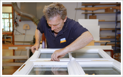 an expert repairing the hinges of a double glazed window
