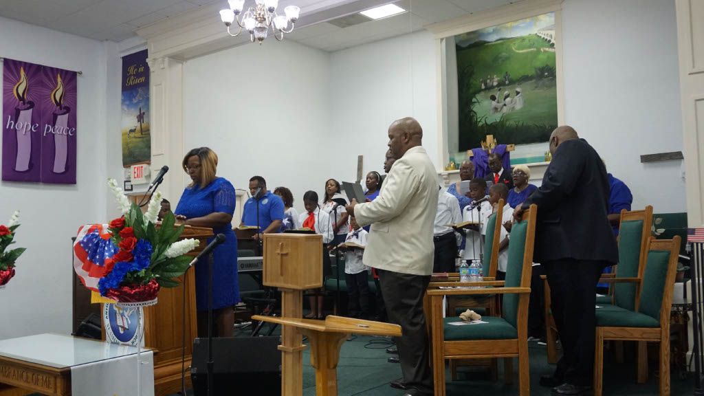 A group of people are standing around a podium in a church.