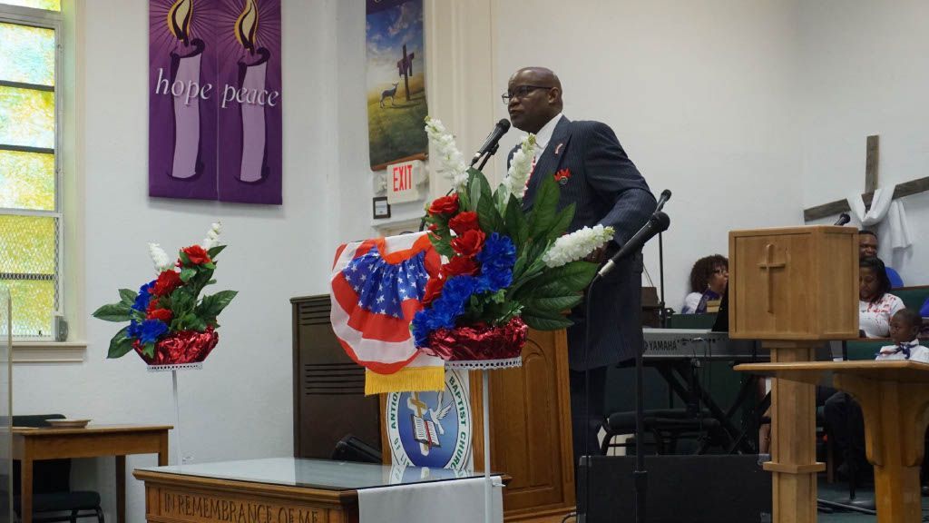 A man is standing at a podium giving a speech in a church.