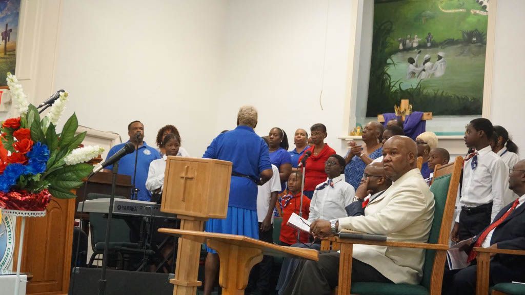 A group of people are sitting in chairs in front of a podium in a church.