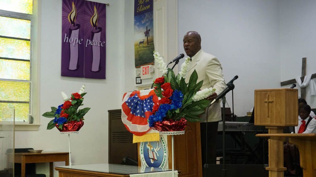 A man is standing at a podium giving a speech in a church.