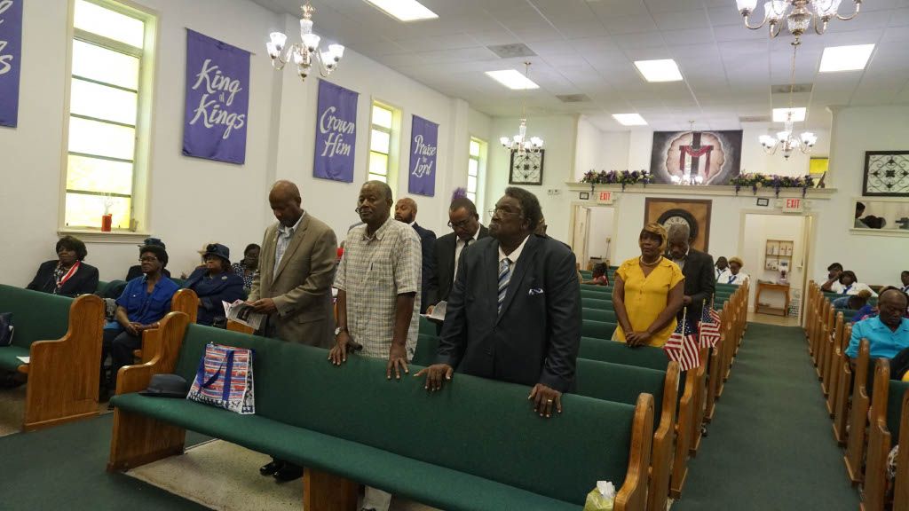 A group of people are standing in a church.