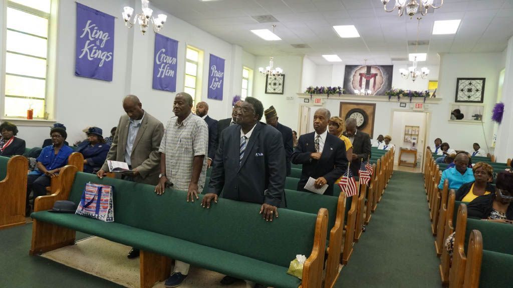 A group of men are standing in a church.