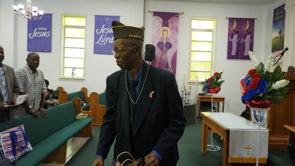 A man in a suit and hat is walking in a church